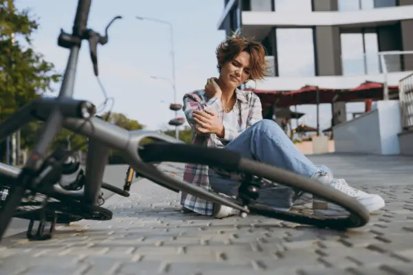 Injured woman cyclist holding shoulder after bike accident demonstrating how to claim for bicycle accident in urban area