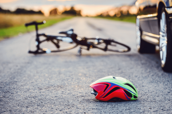 Bicycle helmet on road after car collision showing evidence needed for how to file a claim after a bicycle accident