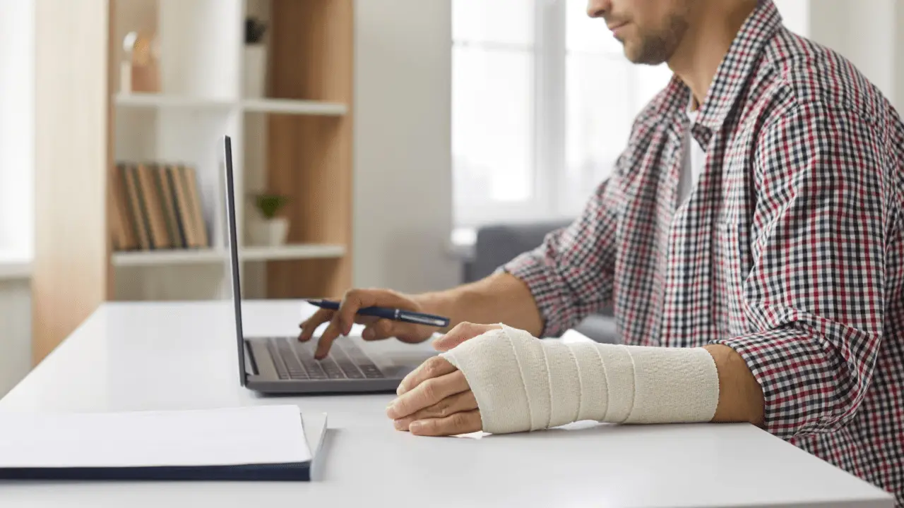 Injured cyclist with bandaged arm using laptop researching how to find a lawyer after a bicycle accident