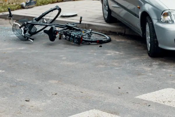 Damaged bicycle on pavement after serious collision with car demonstrating what to do after a serious bicycle accident