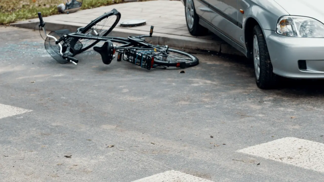 Damaged bicycle on pavement after serious collision with car demonstrating what to do after a serious bicycle accident