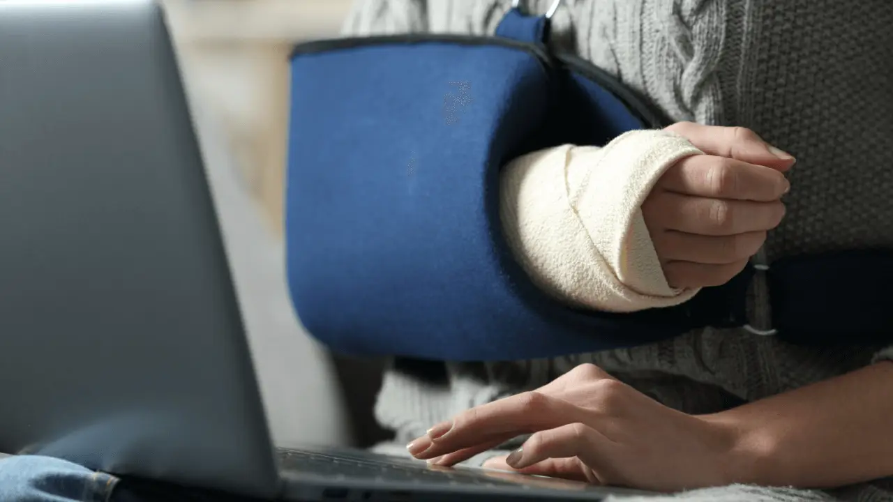 Injured person with cast researching how to choose a personal injury lawyer on laptop
