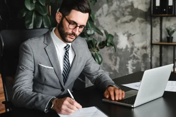 rofessional personal injury lawyer reviewing case documents at modern office desk