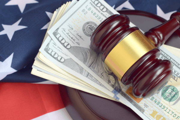 Judge's gavel on stack of hundred dollar bills with American flag representing what affects attorney fees in personal injury claims