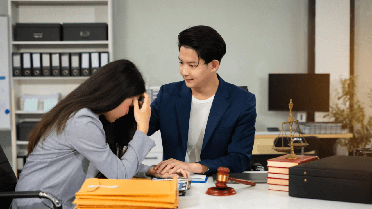 Distressed client receiving support from attorney while asking what is the hardest question to ask a lawyer during consultation