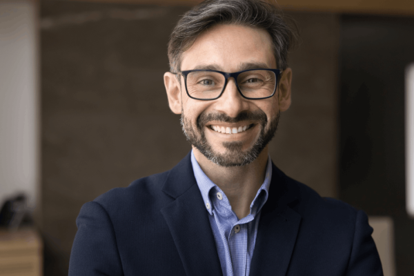 Professional personal injury lawyer smiling confidently, illustrating what is the purpose of a personal injury lawyer in client representation