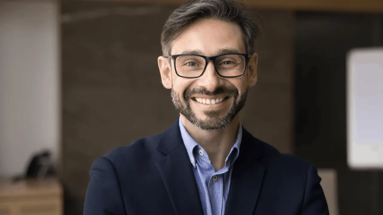 Professional personal injury lawyer smiling confidently, illustrating what is the purpose of a personal injury lawyer in client representation