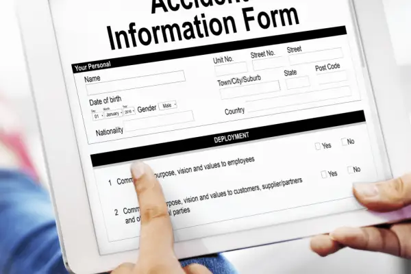 Person completing truck accident legal process information form on tablet for injury claim documentation