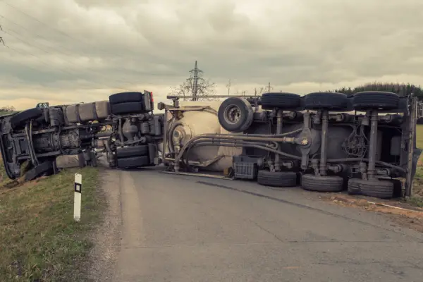 Overturned commercial trucks blocking roadway showing factors affecting truck accident settlements including vehicle damage and accident severity