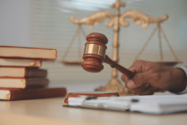 Truck accident lawyer holding judge's gavel with scales of justice and legal books representing commercial vehicle litigation