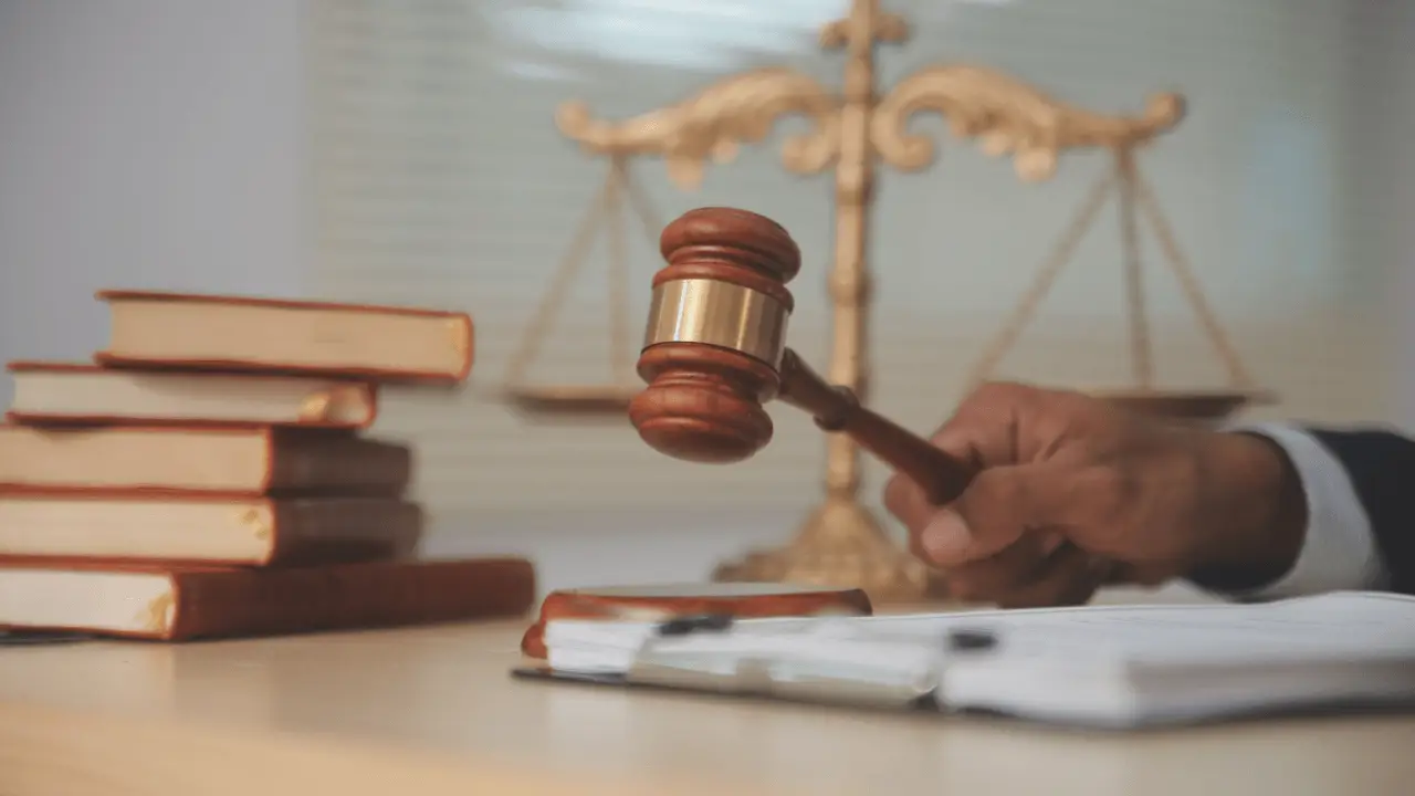 Truck accident lawyer holding judge's gavel with scales of justice and legal books representing commercial vehicle litigation