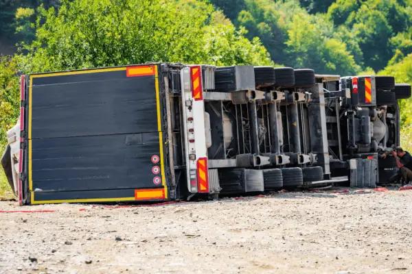 Truck accident settlements explained with overturned commercial vehicle on roadside representing severe collision damages