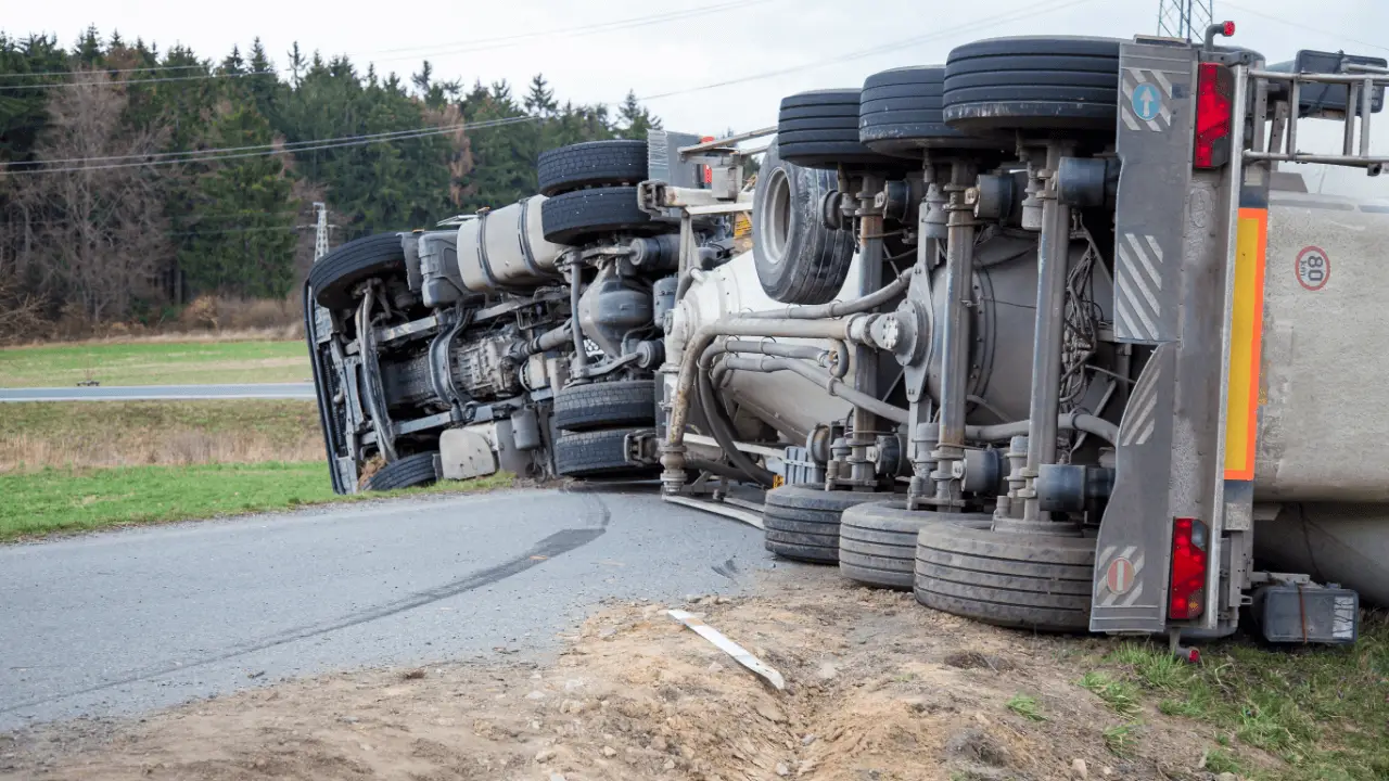 Overturned commercial truck on roadside showing who is at fault in a truck accident investigation scene